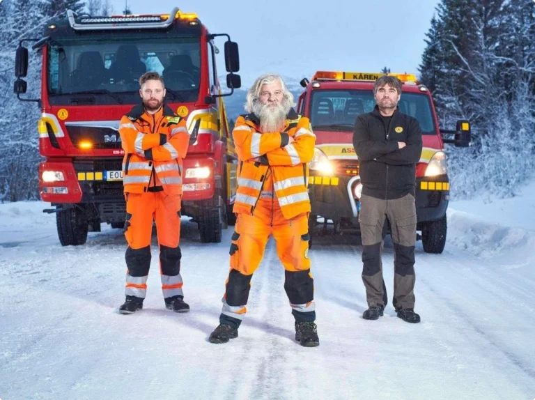 Personal från Årebärgarn uppställda framför sina röda bärgningsbilar i ett snötäckt Åre.