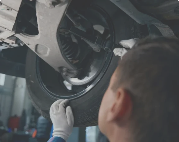 Arbete i en mekanisk verkstad eller plåtverkstad med reparation och kontroll under bilen.